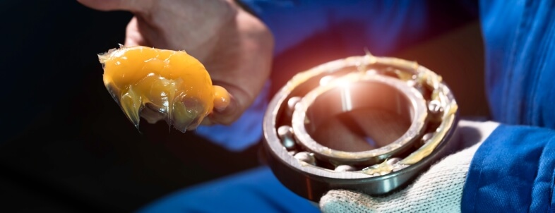 Hand applying grease to a bearing