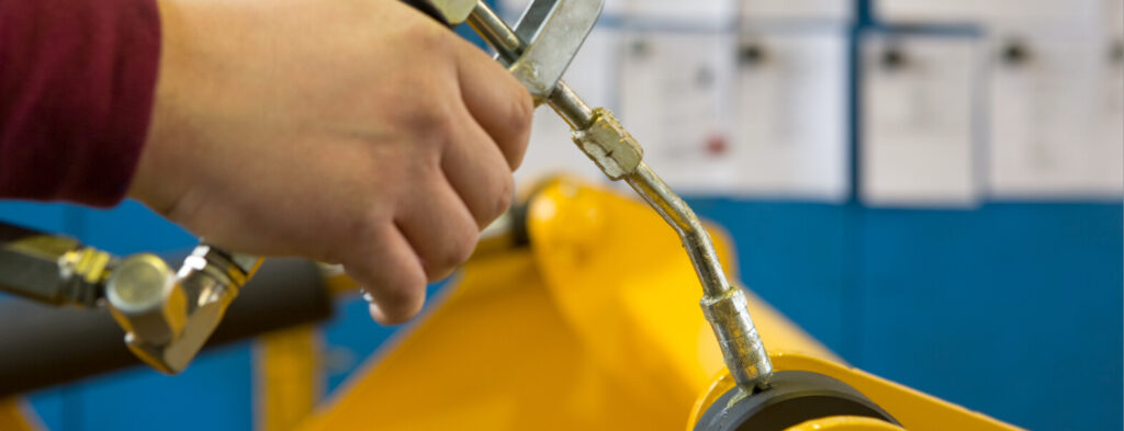 Technician greases robot joints.